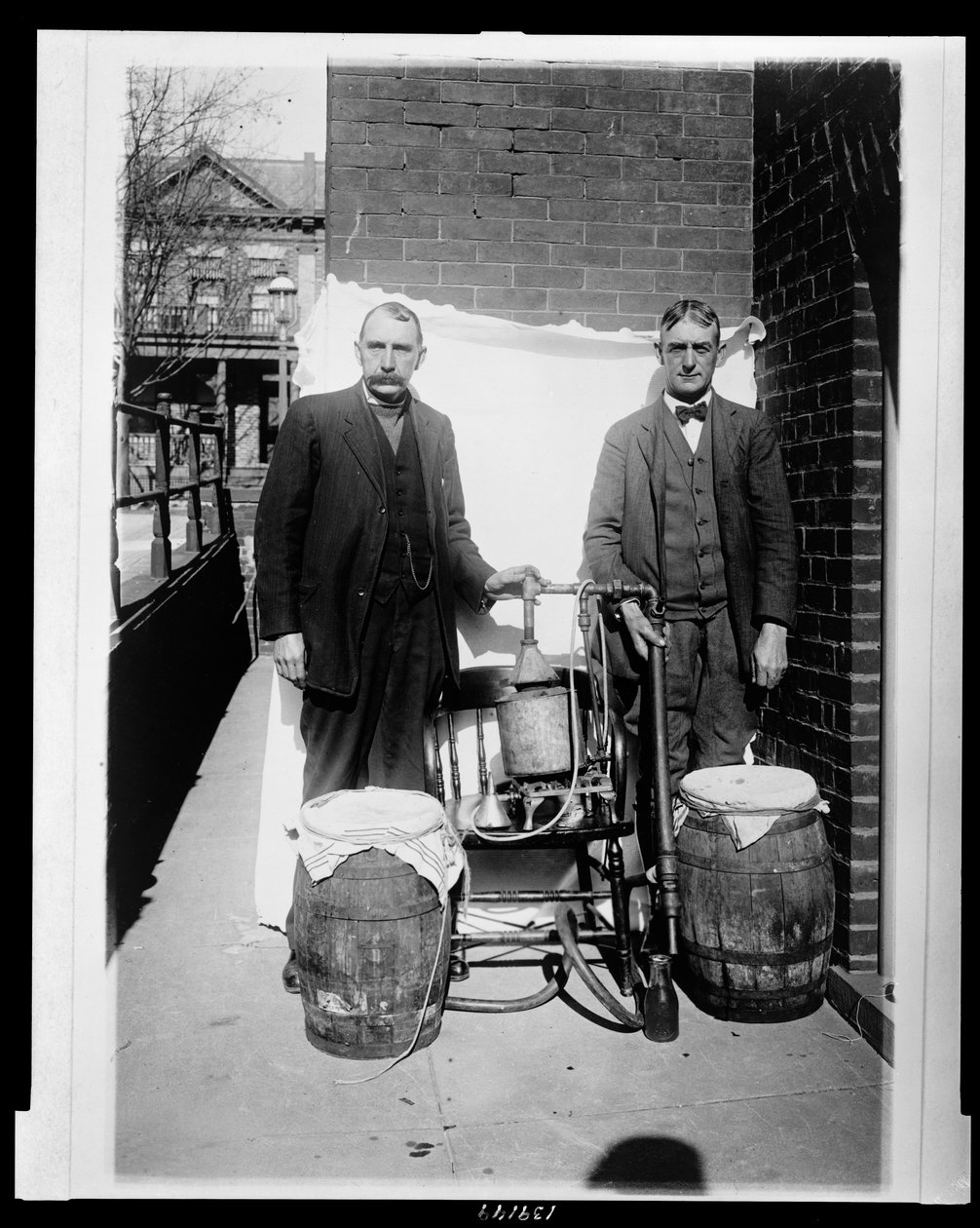 Zwei Männer posieren mit einer Whiskey-Destille von American Photographer