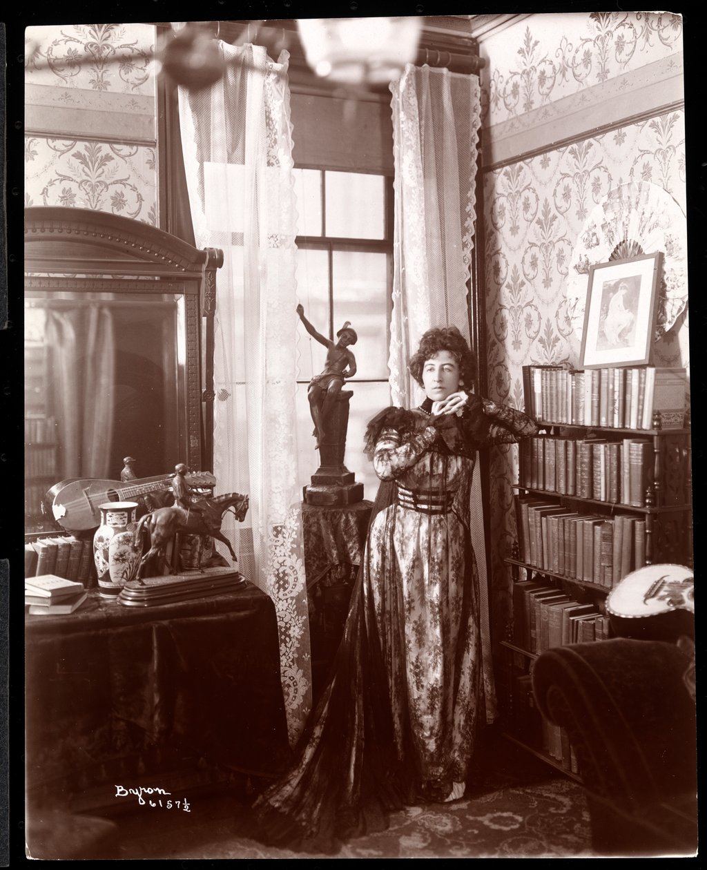 Anita Chartres steht in der Ecke eines Zimmers, ca. 1898 von Byron Company