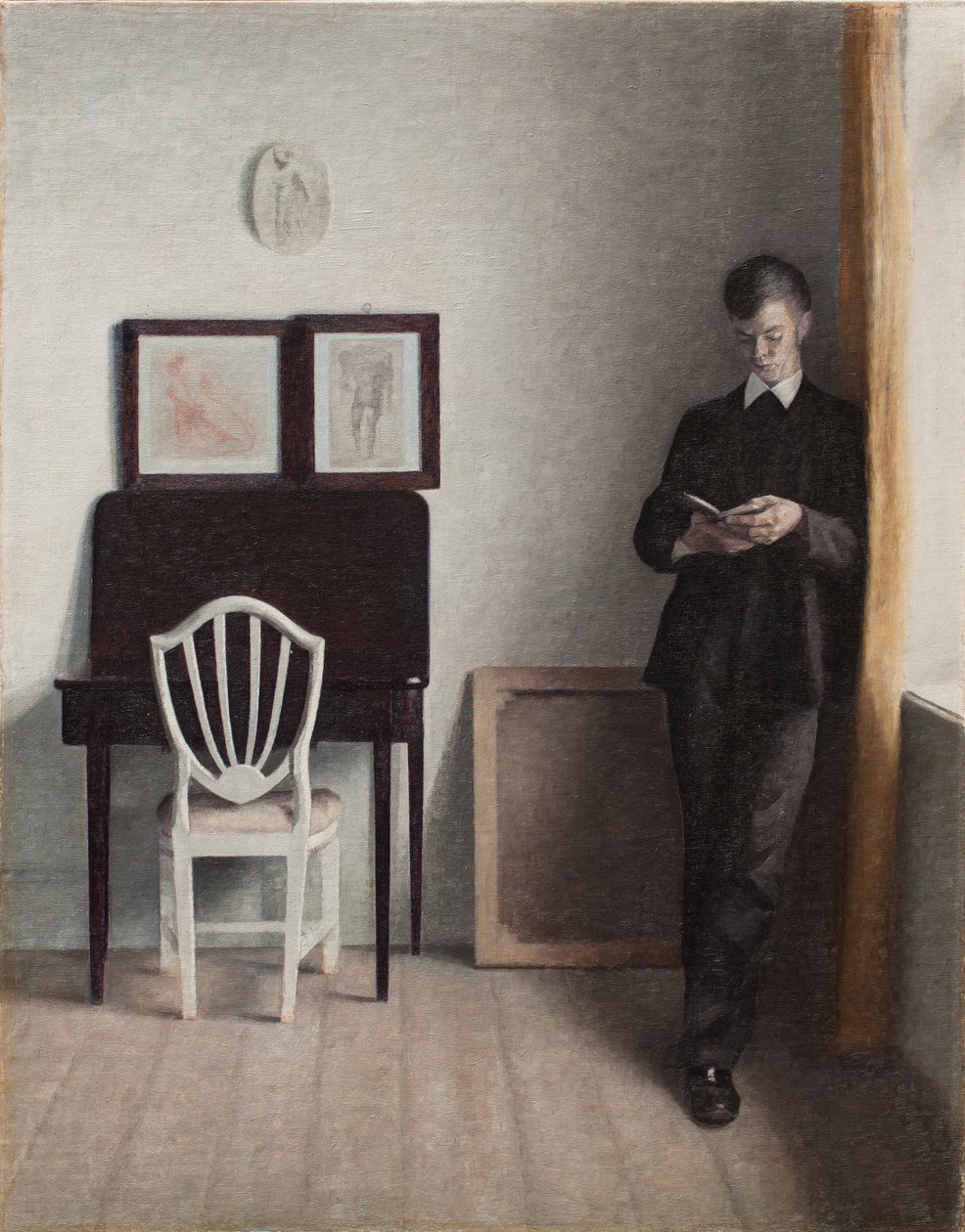 Innenraum mit einem jungen Mann, der liest von Vilhelm Hammershoi