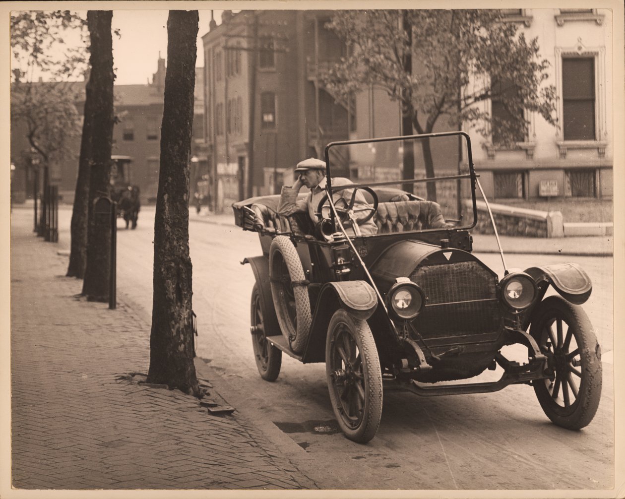 Mann sitzt in einem Auto auf einer nicht identifizierten Straße. von William G. Swekosky