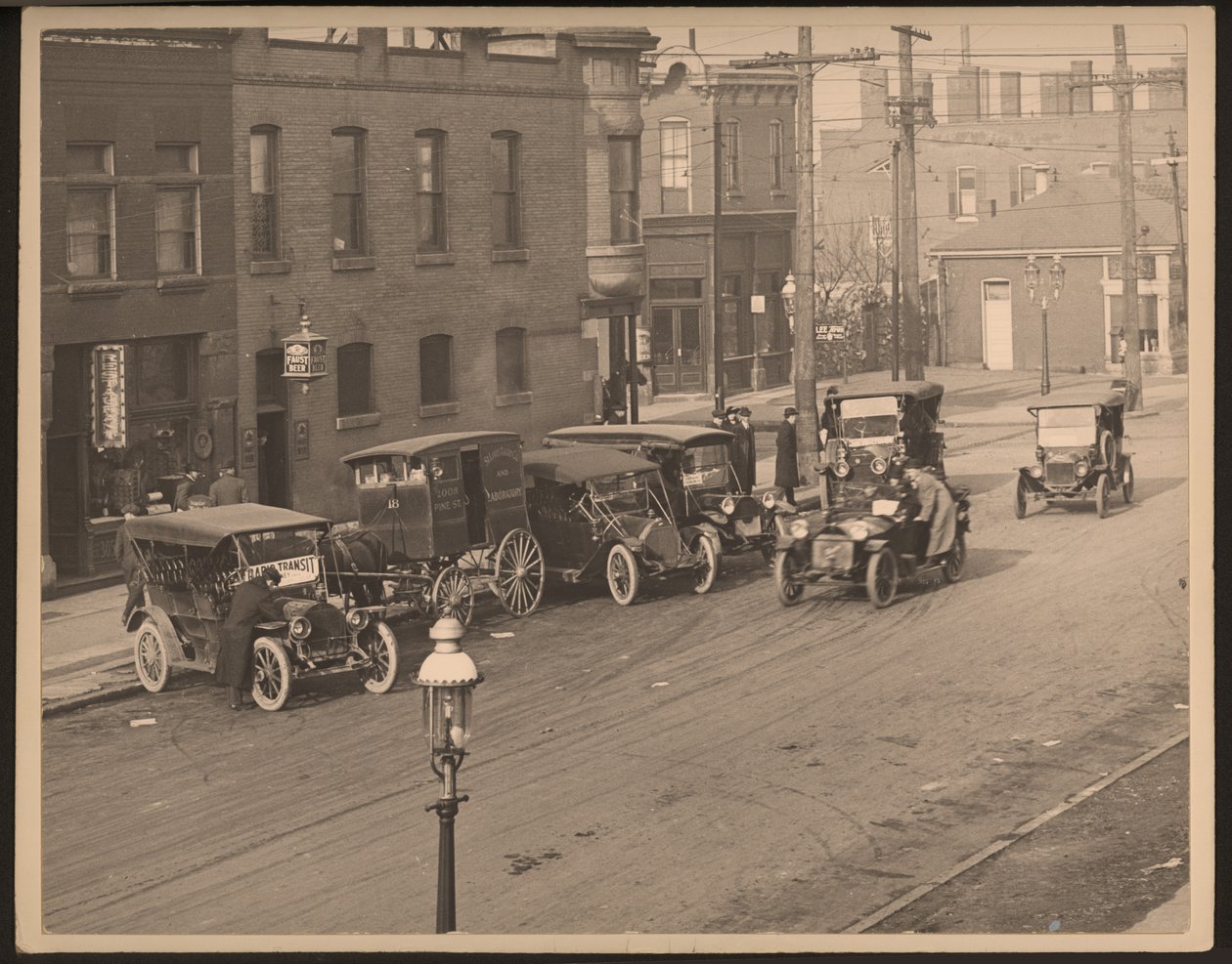 Ansicht einer unbekannten Straße mit mehreren Autos und einem Pferdewagen der St. Louis Bakery Company am Straßenrand von William G. Swekosky