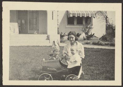 Frau mit Kindern im Spielzeugauto von Louis Fleckenstein