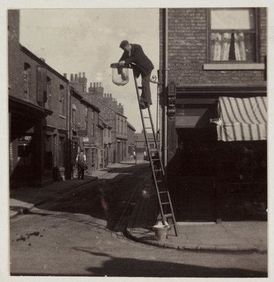 Mann reinigt eine Gaslaterne, um 1905 von Unbekannt