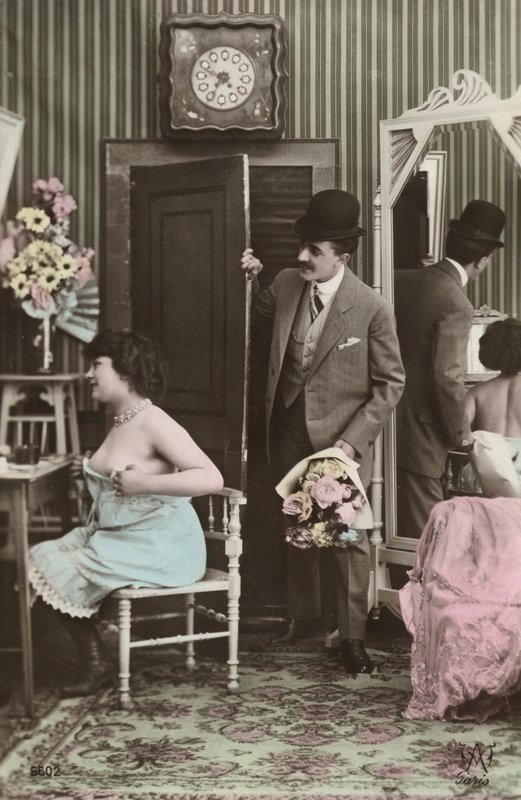 Mann bringt einer sich anziehenden Frau einen Blumenstrauß von French Photographer
