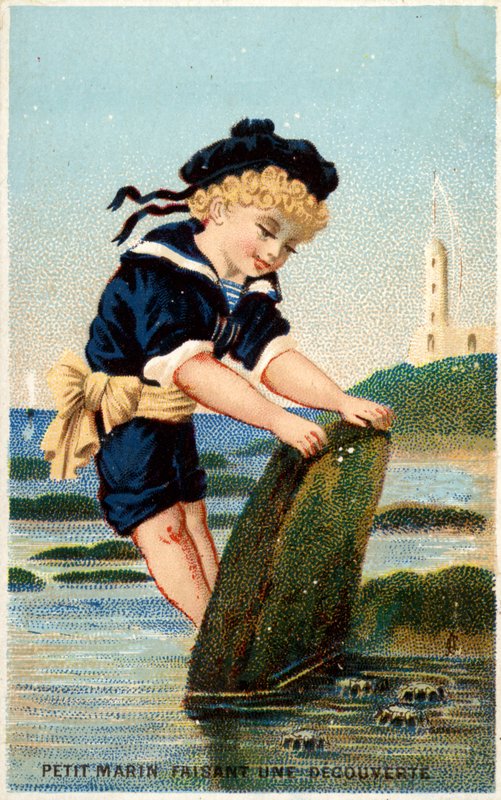 Junge schaut unter einen Stein am Strand von French School